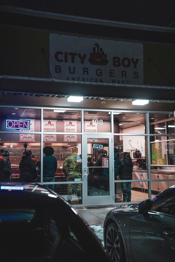 City Boy Burgers Anchorage location storefront at night with customers